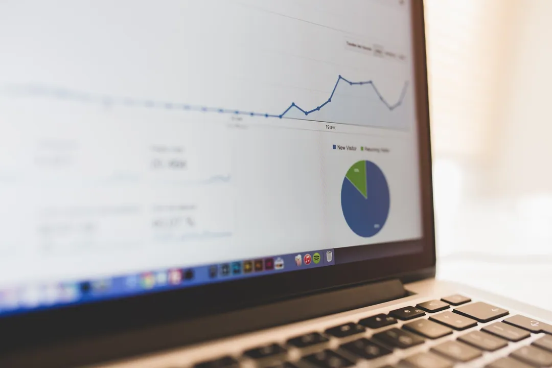 Laptop menampilkan grafik analitik trafik website di atas meja kerja